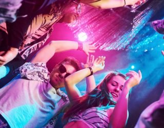 view-from-below-of-young-people-that-having-fun-in-night-club-with-colorful-laser-lights.jpg